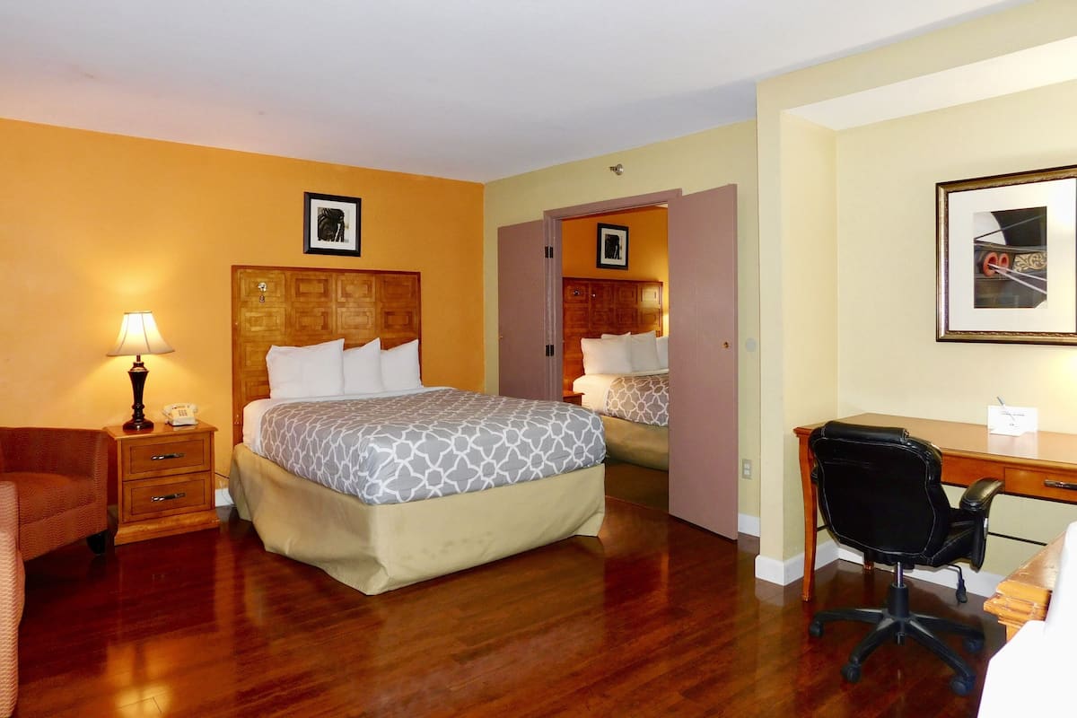 Une chambre d’hôtel équipée d’un lit, d’un bureau, d’une chaise, d’une lampe et d’un téléphone.