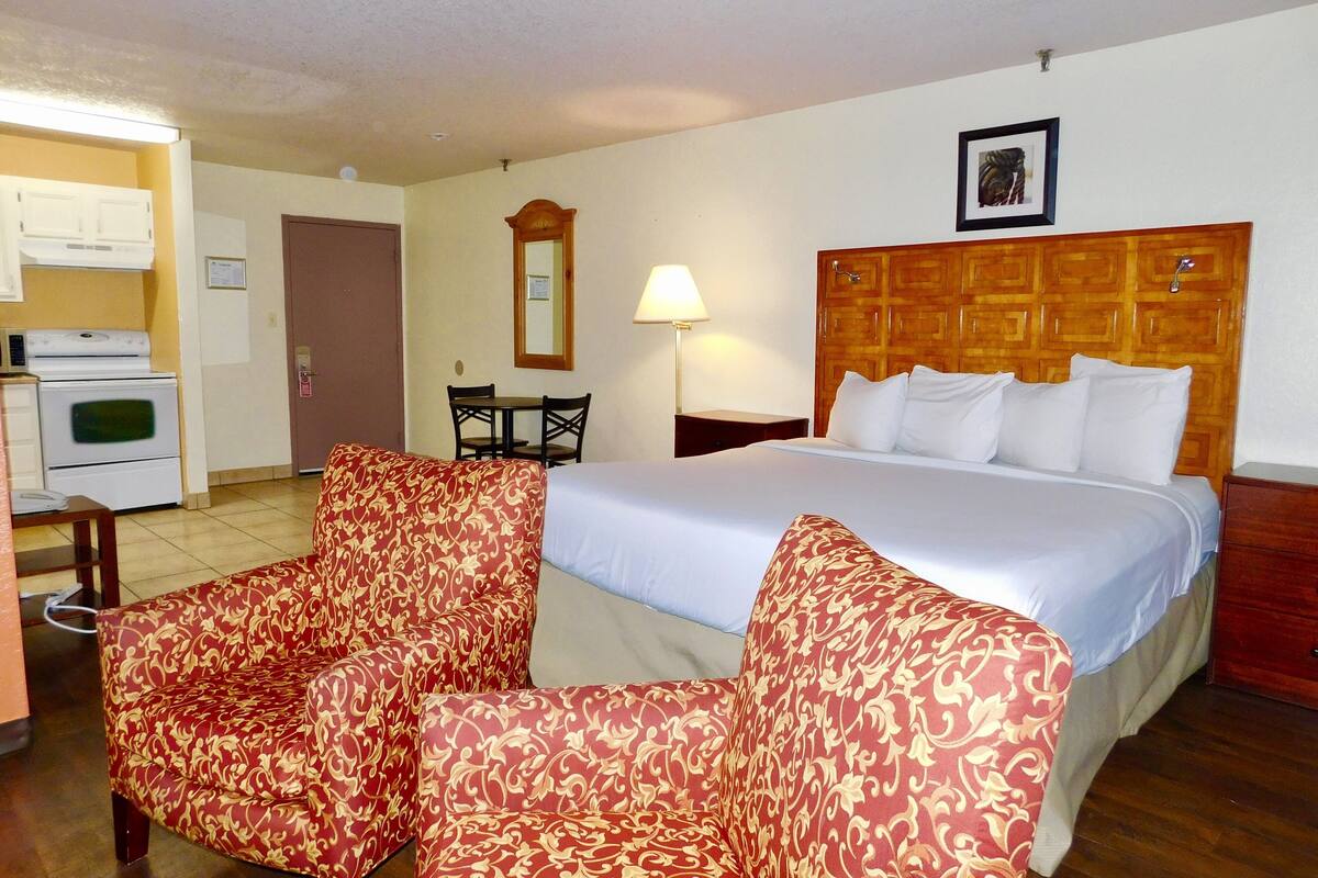 classic room, 1 king bed, non smoking | in-room safe, desk, iron/ironing board, cots/infant beds