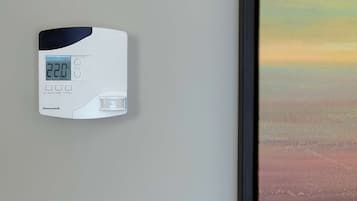 Un termostato Honeywell en una pared con pantalla digital que muestra 22.0°C.