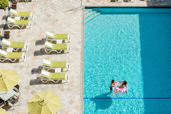 Piscine extérieure en saison, chaises longues