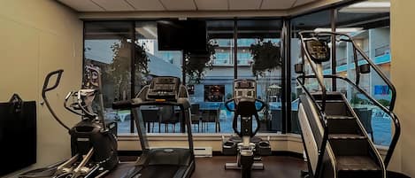 Un gimnasio con cintas de correr, elípticas y escaladoras.