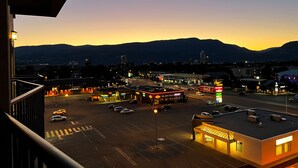 Un estacionamiento con una gasolinera y un edificio con señalización iluminada.