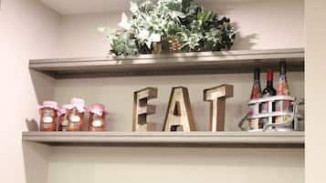 A shelf with jars, wooden letters spelling "EAT," and bottles.