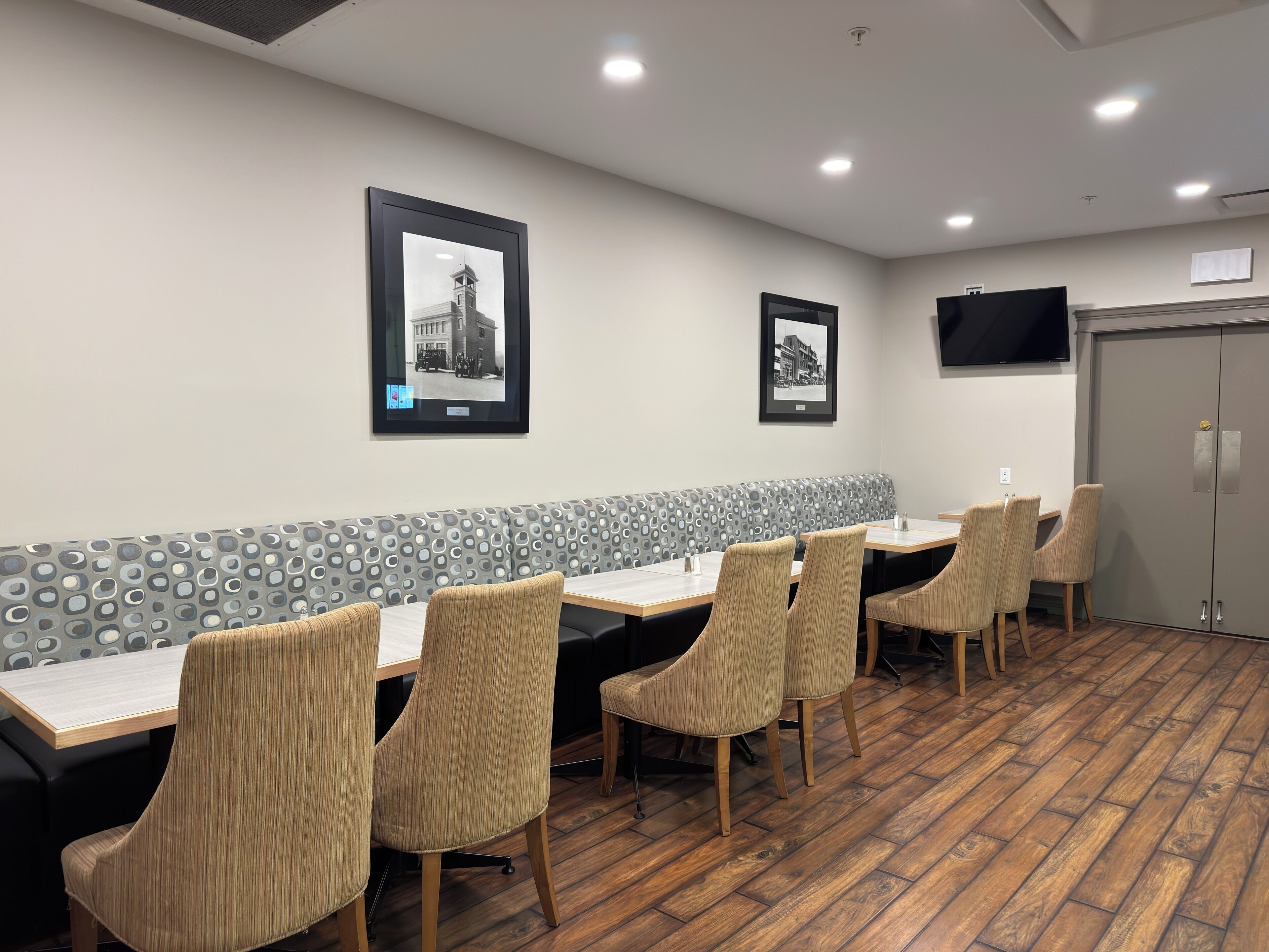 Una sala conferenze con un lungo tavolo, sedie, un muro decorato e quadri appesi.
