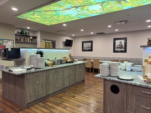 Una cocina moderna con una isla central, armarios de madera y un techo con un diseño de iluminación inspirado en la naturaleza.