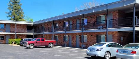 A multi-story parking garage with a red pickup truck and two white sedans parked.