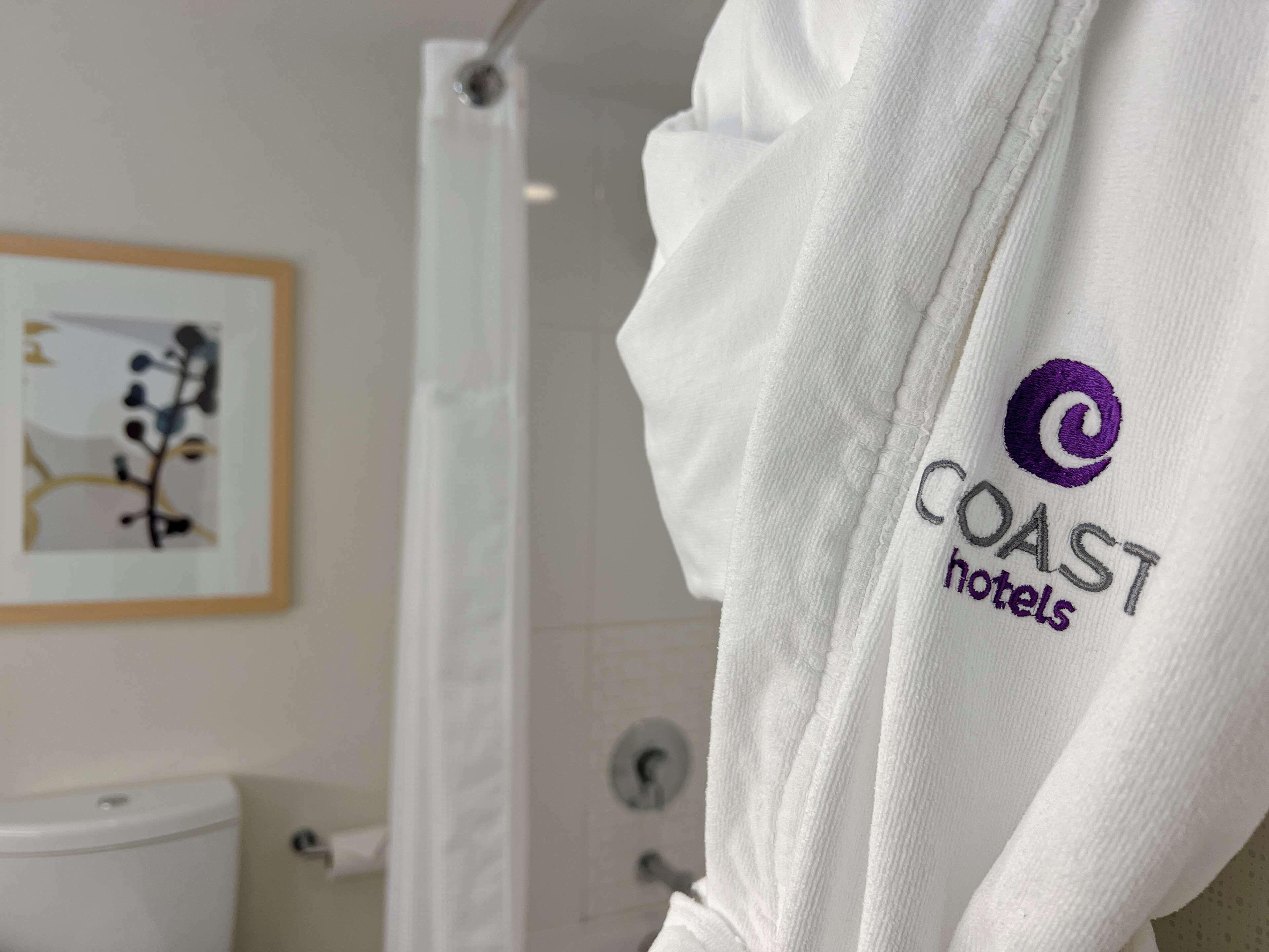 Una bata blanca con el logotipo de Coast Hotels.