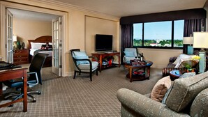 A hotel room with a bed, a desk, a TV, a sofa, and a view of the city. - Crowne Plaza Portland Downtown Convention Center by IHG (Portland)
