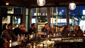 A bar with a view of the city at night, featuring large windows and hanging spherical lights. - Crowne Plaza Portland Downtown Convention Center by IHG (Portland)