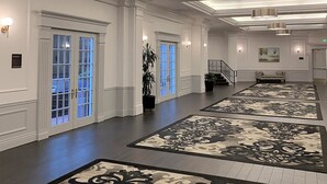 A spacious lobby with a grand staircase, large windows with blue-tinted glass, and decorative rugs on the floor. - Crowne Plaza Portland Downtown Convention Center by IHG (Portland)
