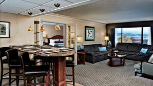 A hotel room with a dining area, a sofa set, and a view of a bridge. - Crowne Plaza Portland Downtown Convention Center by IHG (Portland)