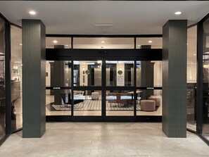 A hotel lobby with a glass door entrance, a reception desk, and seating area. - Crowne Plaza Portland Downtown Convention Center by IHG (Portland)