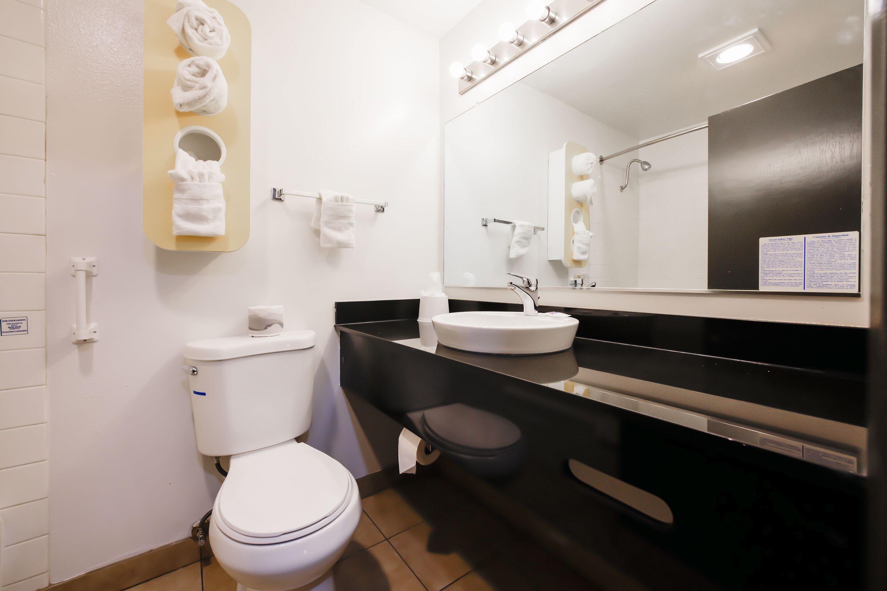 A modern bathroom with a toilet, sink, and mirror.