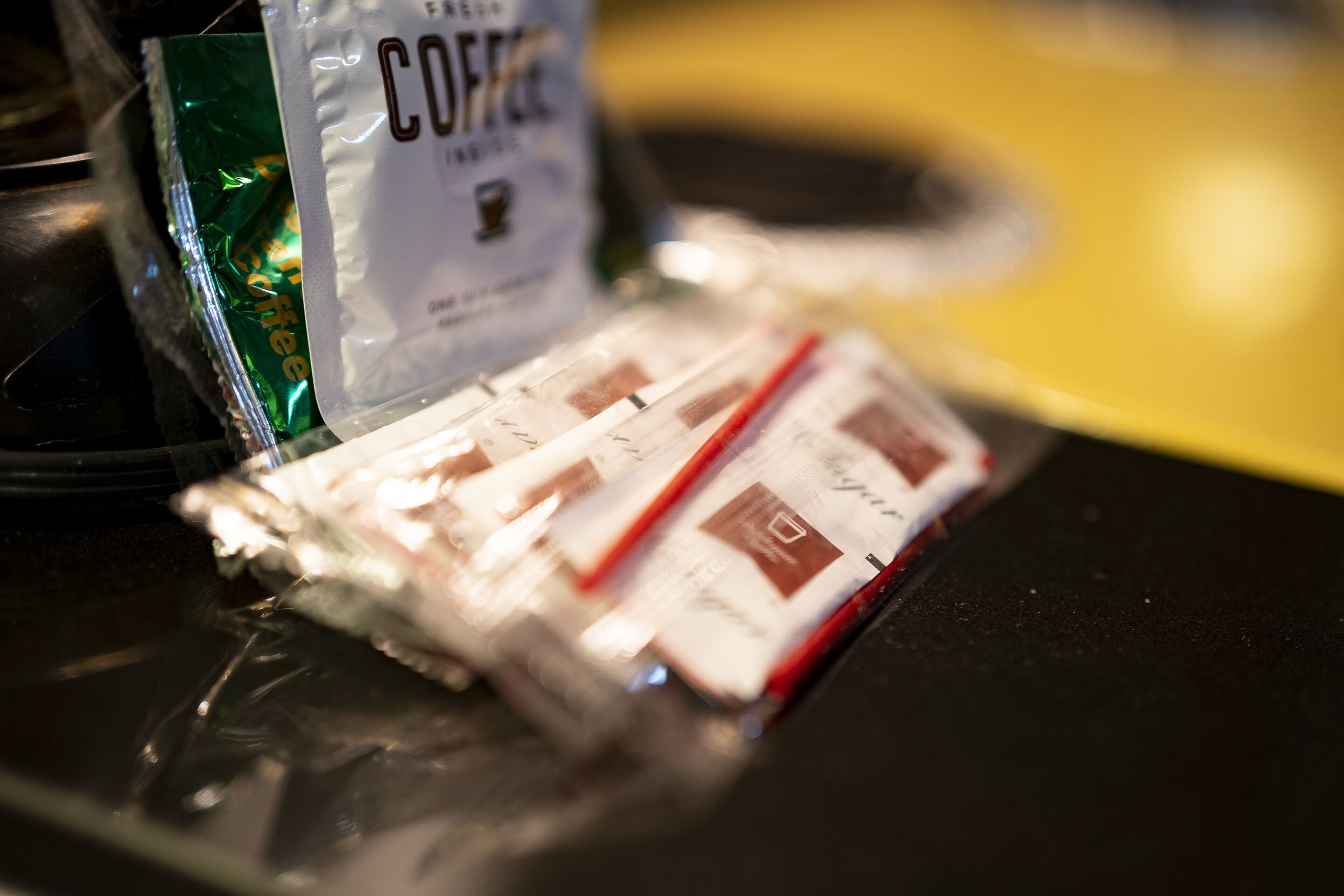 A coffee bag and a coffee pod on a black surface.