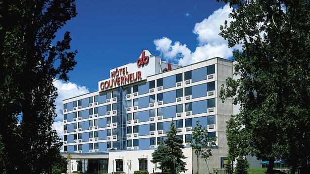 A modern hotel building with a sign reading "Hôtel Gouverneur." It features a symmetrical facade with multiple windows and a central entrance. - Hôtels Gouverneur Montréal - Île Charron (Longueuil)