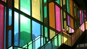 A multi-level interior with a staircase and large windows allowing natural light to filter through. - Hôtels Gouverneur Montréal - Île Charron (Longueuil)