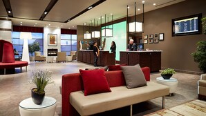 A modern lobby with a reception desk, seating area, and a fireplace.
