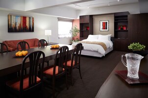 Une chambre d’hôtel moderne dotée d’un coin repas, d’un lit et d’une grande fenêtre.