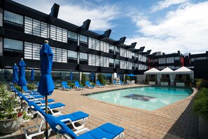 Una piscina al aire libre, tumbonas