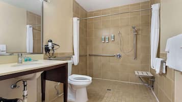 A bathroom with a shower, toilet, sink, and hand dryer.