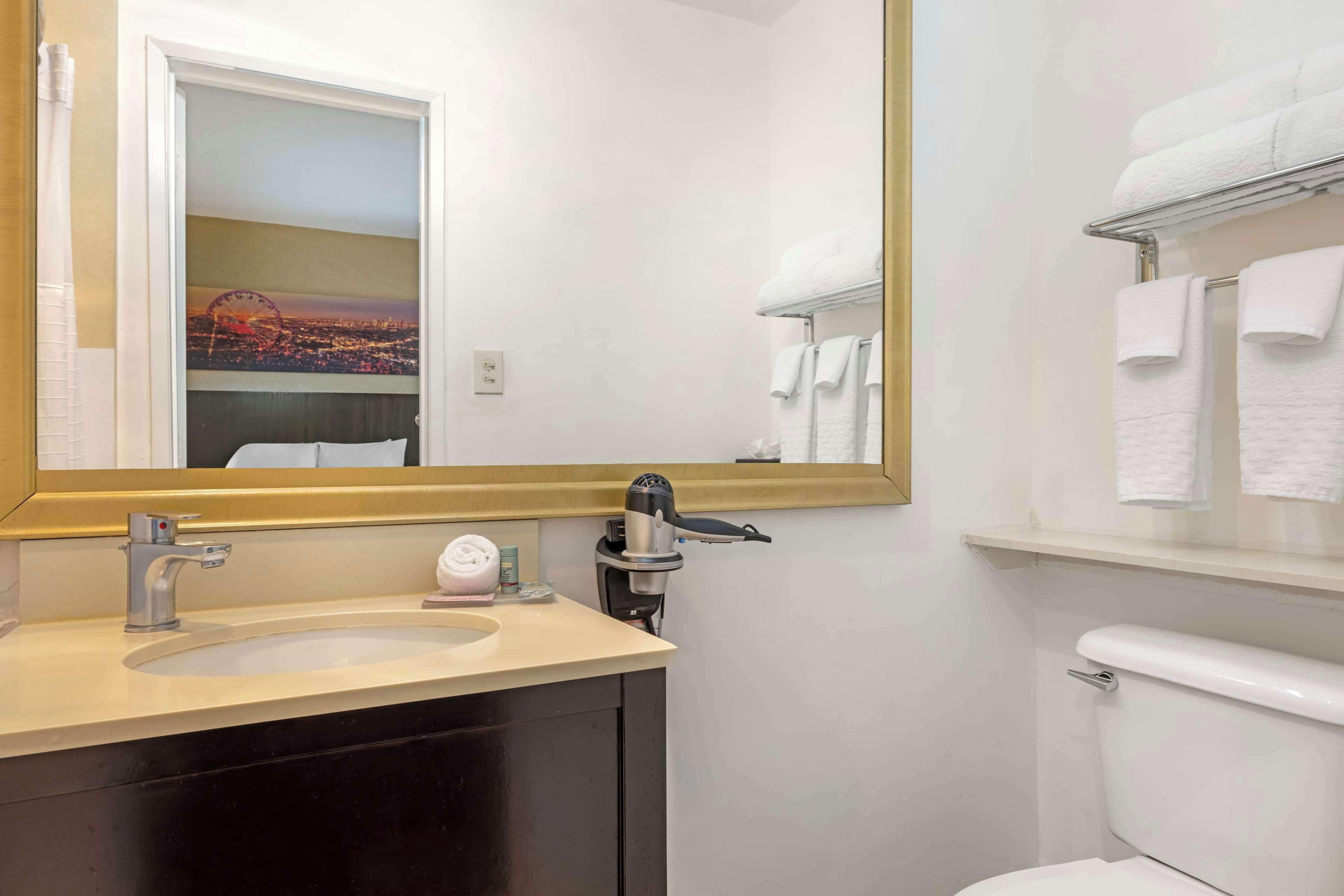 Un baño con lavamanos, espejo e inodoro.
