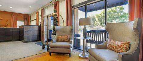 A modern living room with a sofa, armchair, and a small table.