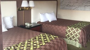 A hotel room with two beds, a nightstand with a lamp, and a wall with a decorative piece. - American Inn (Stockton)