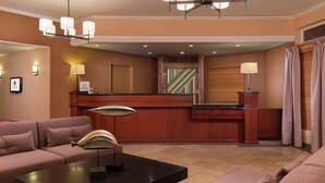A hotel lobby with a reception desk, a sofa, a coffee table, and a chandelier. - DoubleTree by Hilton Portland - Tigard (Tigard)