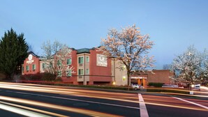 A hotel with a red facade, multiple windows, and signage indicating it is a DoubleTree hotel. - DoubleTree by Hilton Portland - Tigard (Tigard)