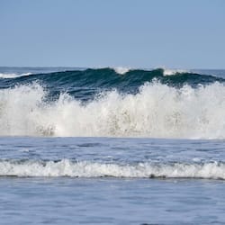 Waves gently break on the shore, offering a serene ocean view.