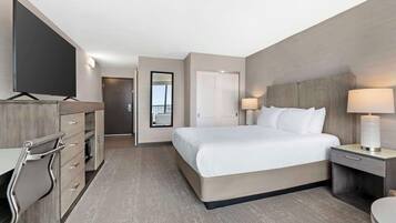 Habitación de hotel con cama, mesitas de noche, televisor y baño.