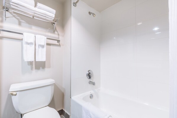 A bathroom with a toilet, a bathtub, and a shower.