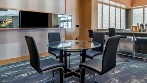 A conference room with a glass table, black chairs, a large flat-screen TV, and a patterned carpet. - Best Western Plus Vancouver Airport Hotel (Vancouver)