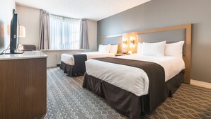 A hotel room with two beds, a desk, and a TV. - Best Western Plus Vancouver Airport Hotel (Vancouver)