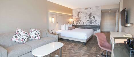 Une chambre d’hôtel avec un lit, un canapé, un bureau et une chaise.
