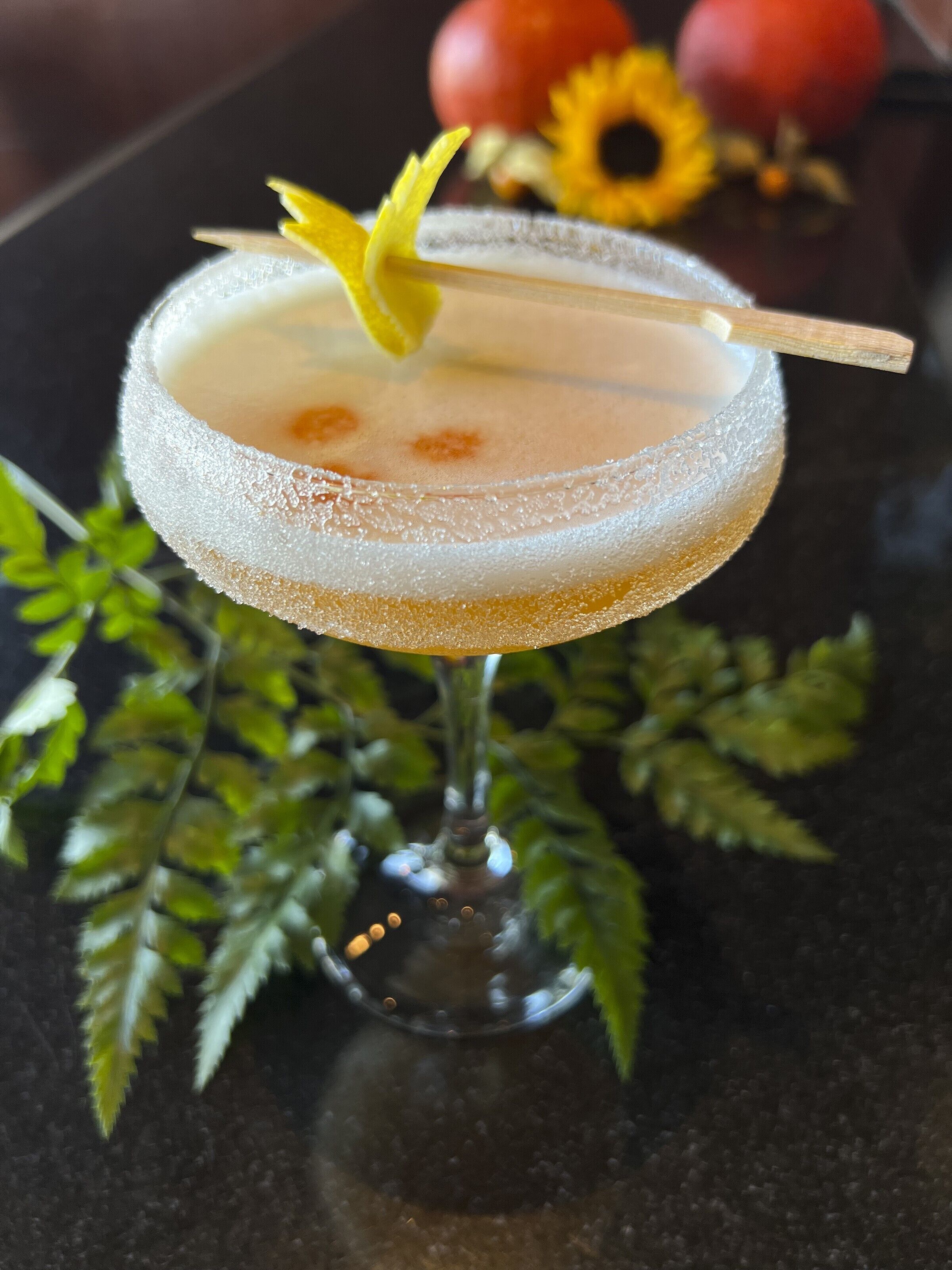 A cocktail in a frosted glass with a lemon twist garnish.