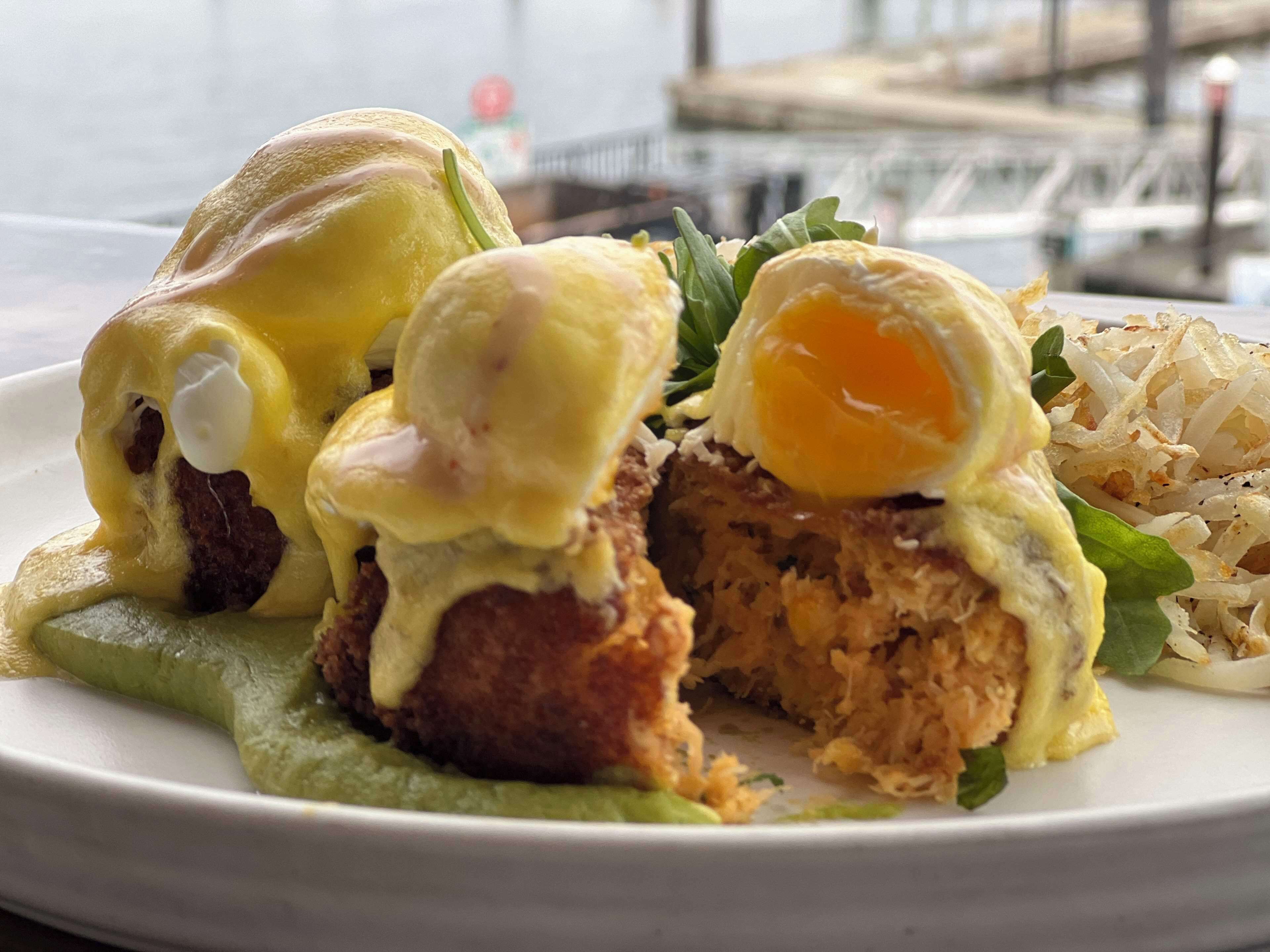 A plate of food with eggs, meat, and greens.