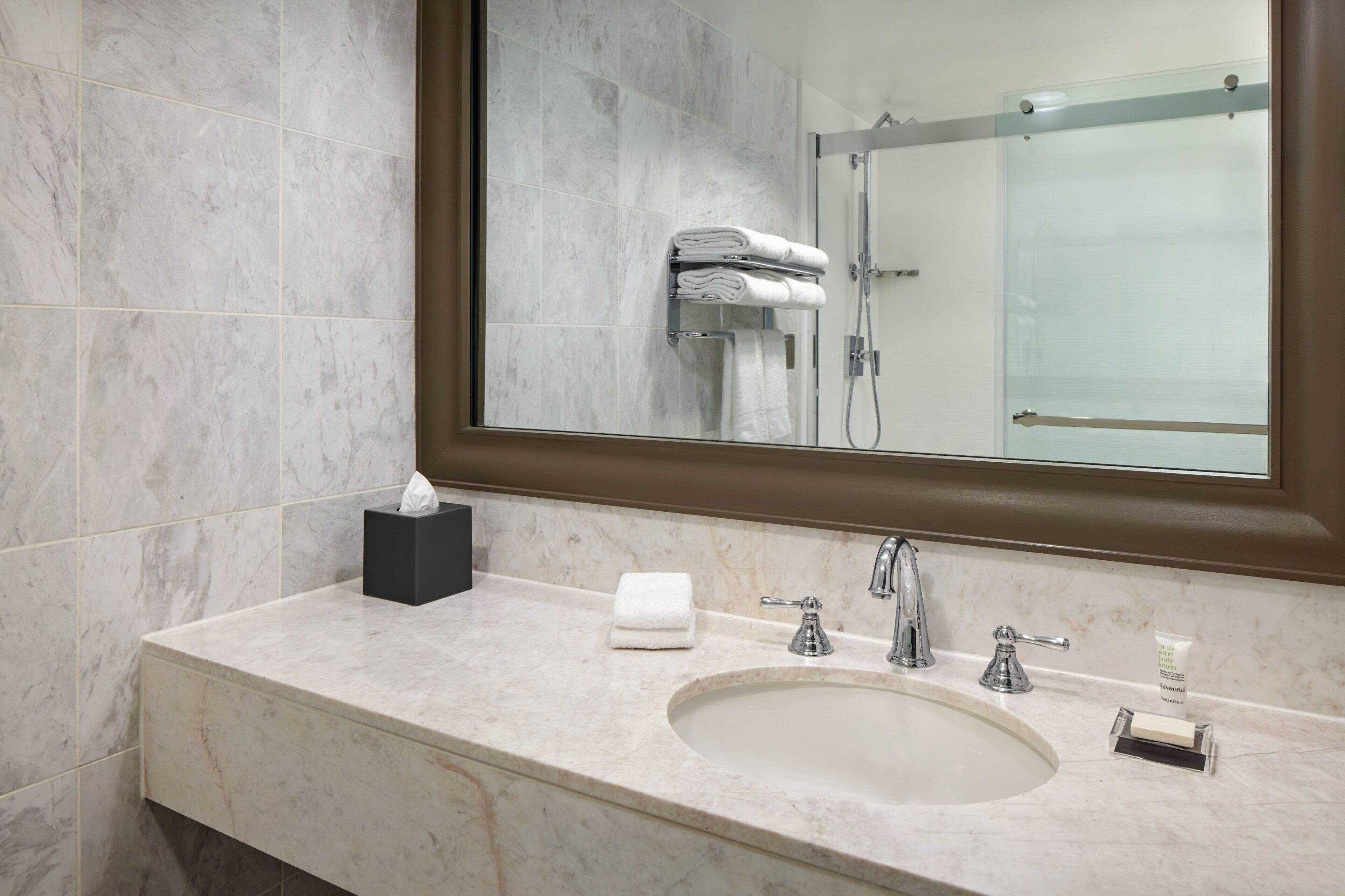 Un baño con un espejo grande, un lavabo y una zona de ducha.