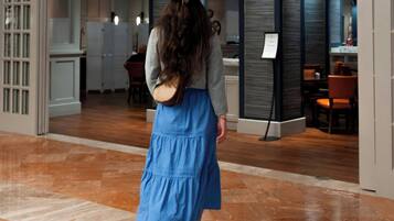 Una donna cammina verso l'ingresso di un hotel con la scritta "Wellington's".