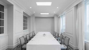 A conference room with a long table, chairs, and a chandelier.