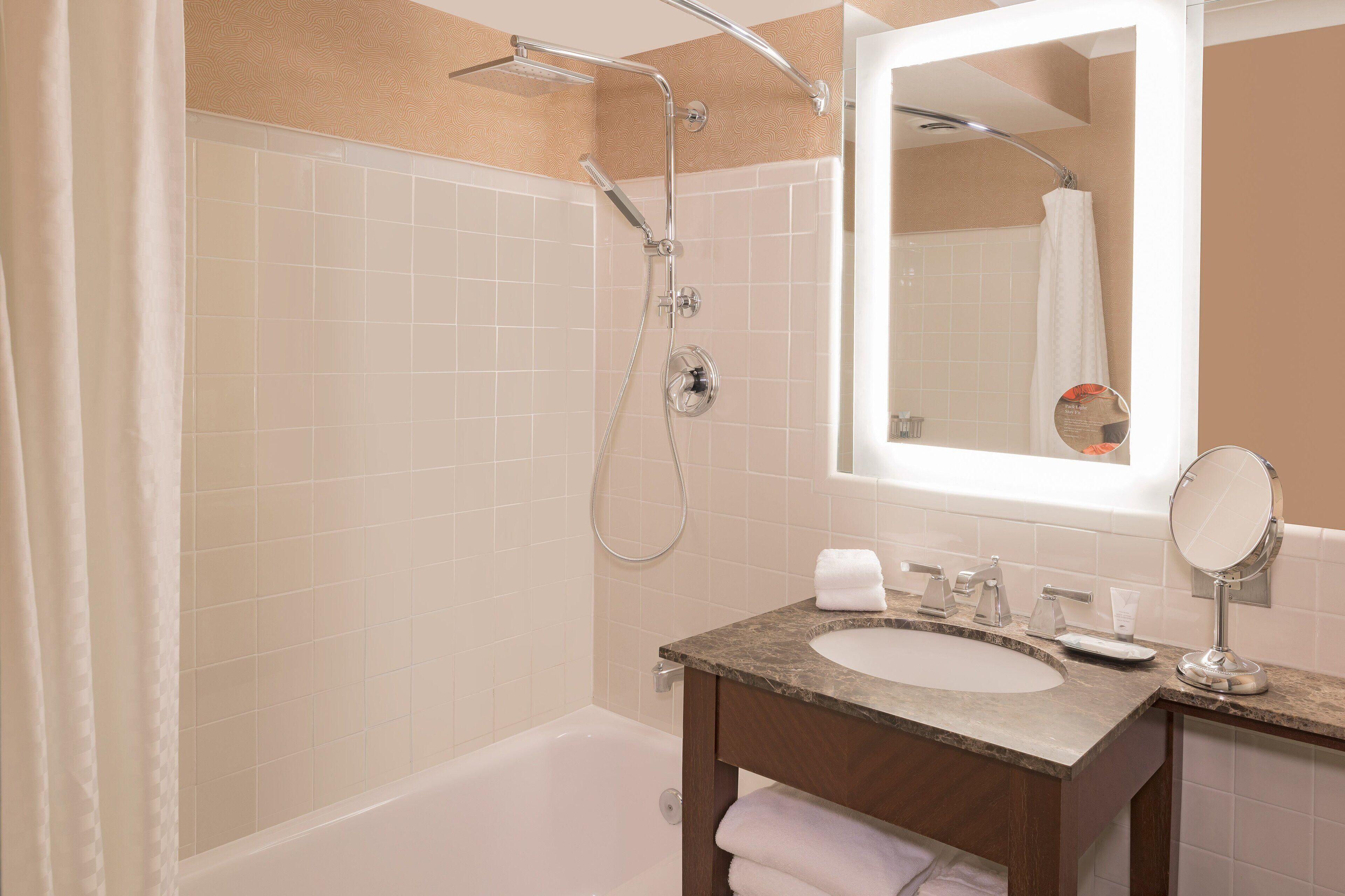 Une salle de bain avec une baignoire, une douche, un lavabo et un miroir.