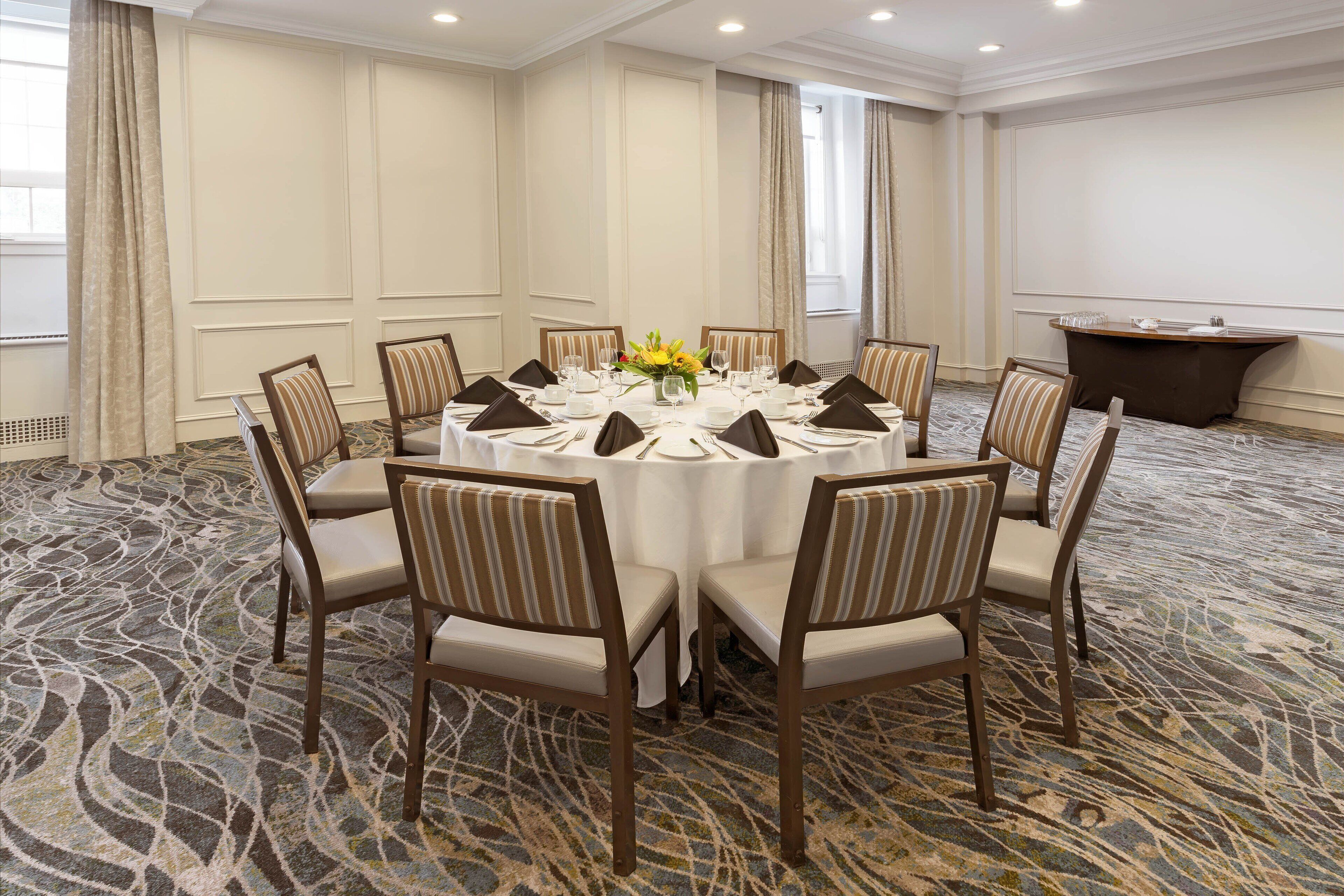 A conference room with a round table, chairs, and a podium.