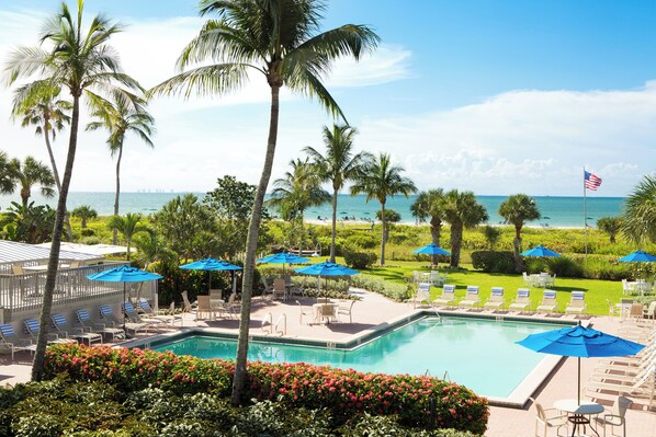 Relax by the oceanfront pool surrounded by palm trees and lush gardens.