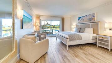 Quarto moderno com uma cama grande, um espaço de estar e uma varanda com vista.