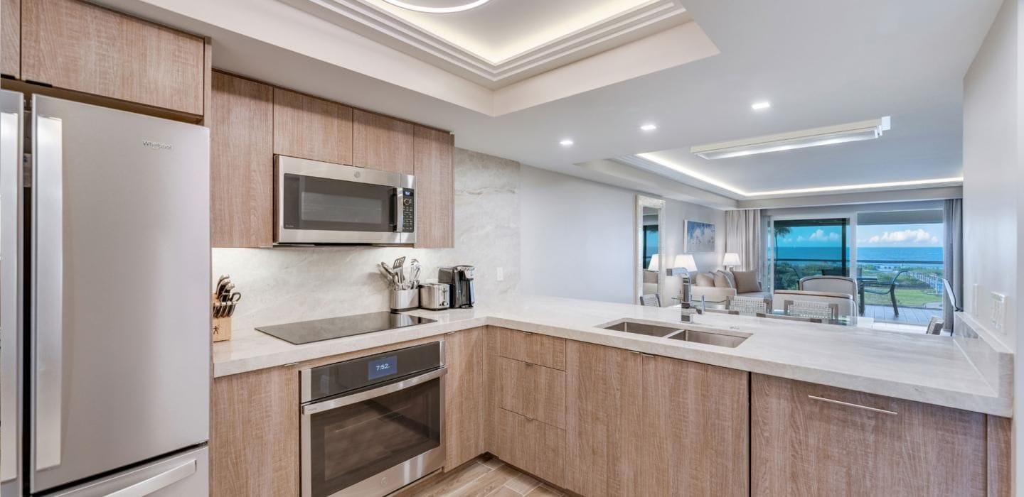 A modern kitchen with a built-in microwave, oven, and stainless steel refrigerator.