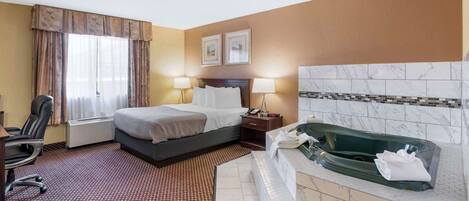 A hotel room with a bed, a desk, a chair, a bathroom with a bathtub, and a shower.