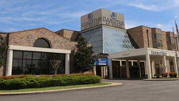 A DoubleTree by Hilton hotel with a brick facade, large windows, and a clear sky.