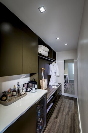 A modern bathroom with a vanity, shelves, and a robe hanging.