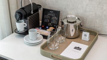 A coffee station with a Nespresso machine, cups, glasses, and a tray with a menu.
