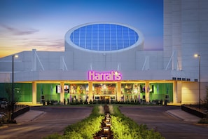 Moderni rakennus, jossa on suuri pyöreä kattovalokuvio ja neonvalomainos, jossa lukee ”Harrah’s”.